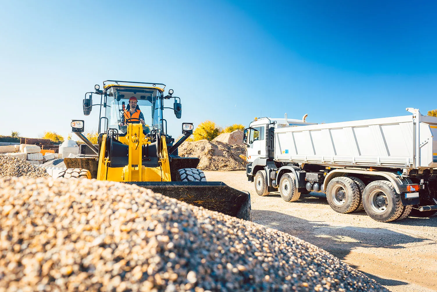 Bauunternehmen Schäfer - Arbeiter beim Tiefbau machen Erdarbeiten mit Radlader und LKW
